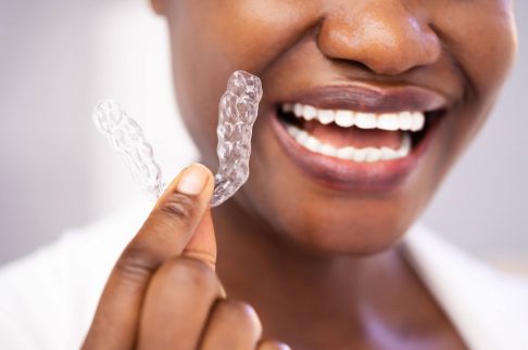 680b1e990413ca7fd3c7f6a4_woman holding clear braces birmingham